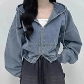Person wearing a blue denim jacket with a plain background